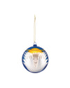 Round blue and white Christmas tree ornament by Alessi, depicting a minimalist angel face with wings and a gold halo.