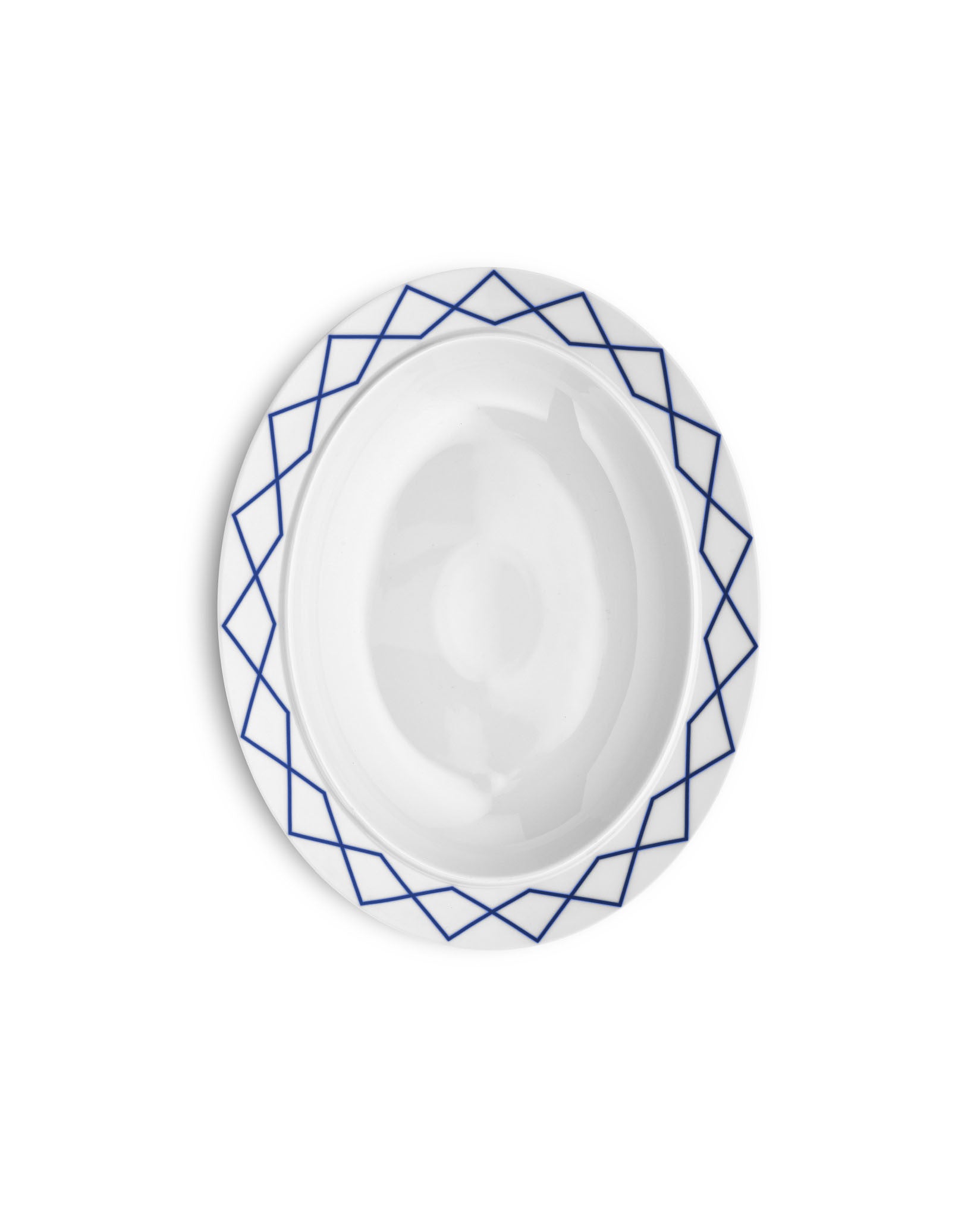 White serving plate by Alessi with a blue geometric pattern around the rim.