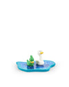 Ornamental figurines by Alessi, featuring a green duck and a white swan on a blue base with wave patterns.