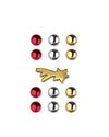 Christmas ornaments by Alessi featuring shiny red, silver, and gold spheres, and a gold shooting star.