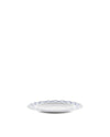 White ceramic side plate by Alessi with a blue diamond-shaped geometric pattern.
