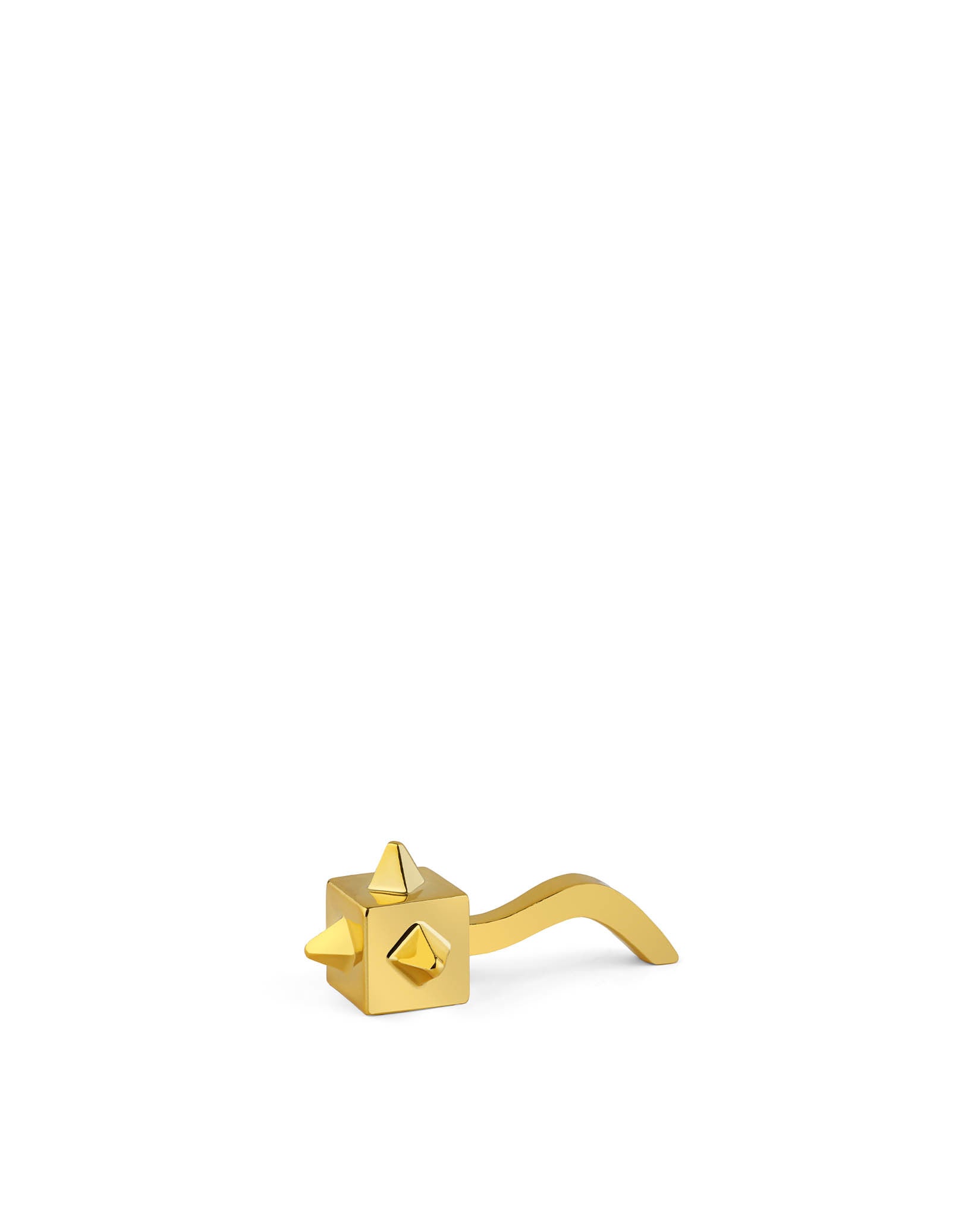 Golden cube-shaped ornamental figurine by Alessi with pyramid studs and a curved extension.