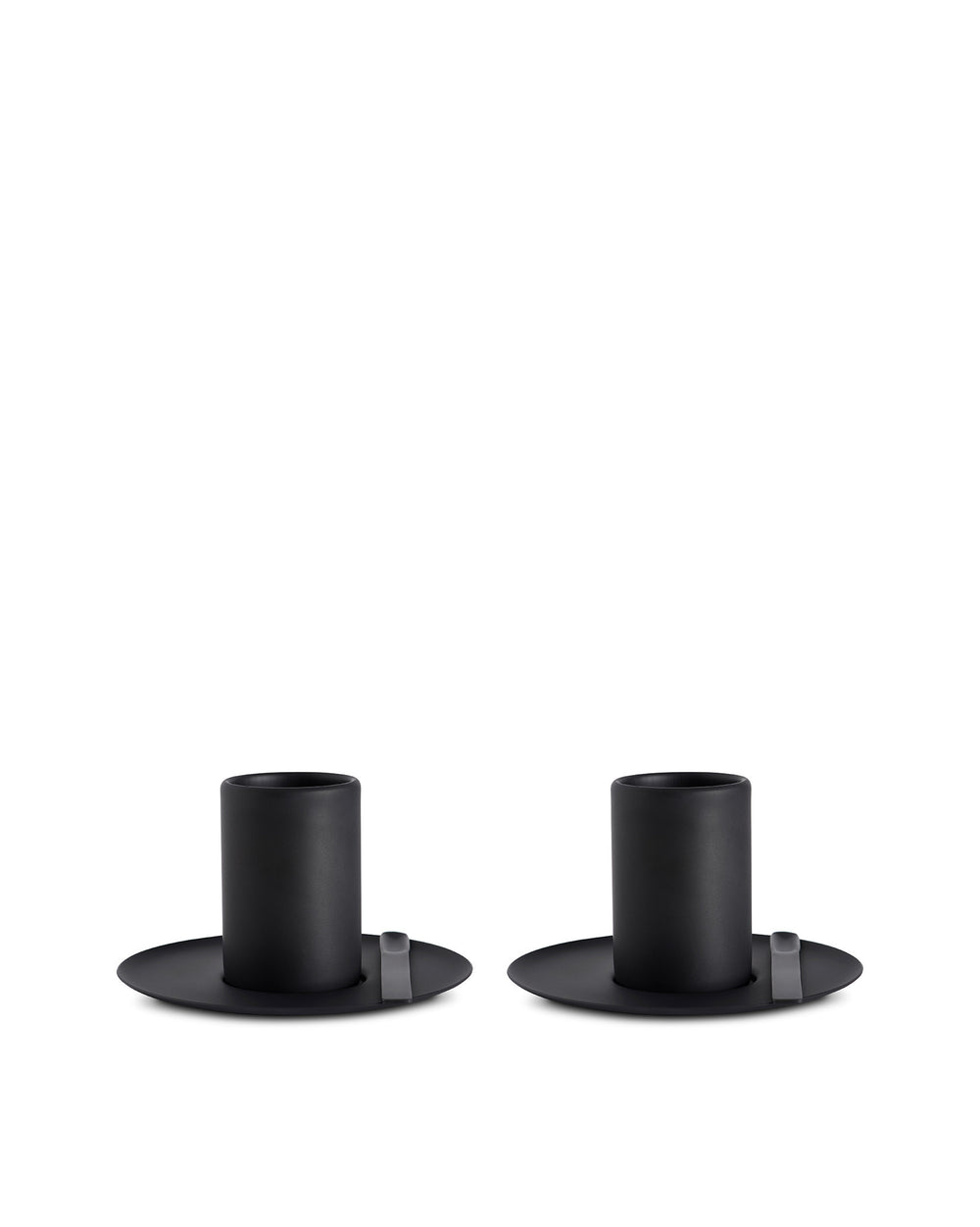 Two matte black cylindrical cups by Alessi with wide flat bases and small grey tabs, placed side-by-side.