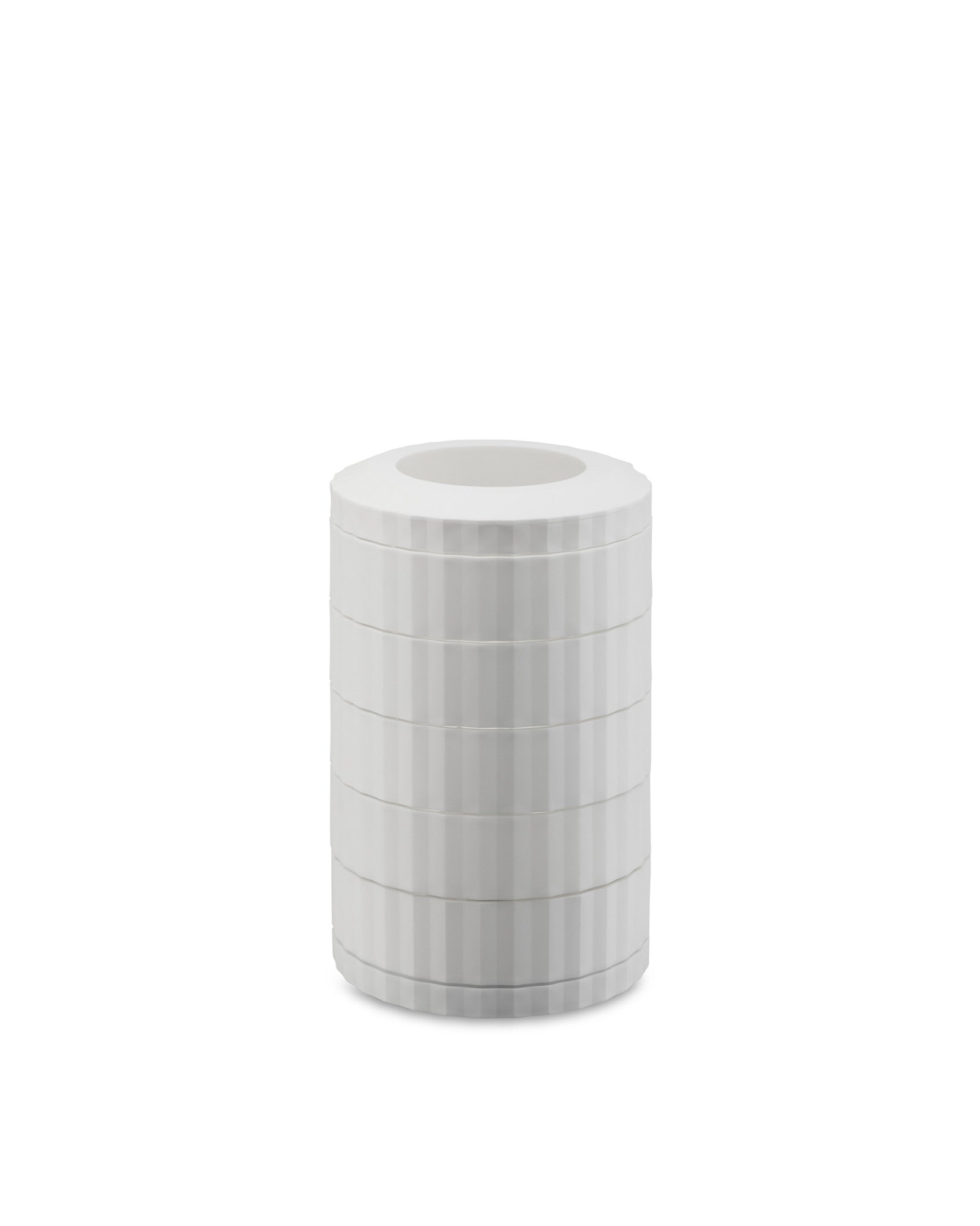 A white cylindrical capsule holder by Alessi, with stacked sections and vertical ribbed texture.