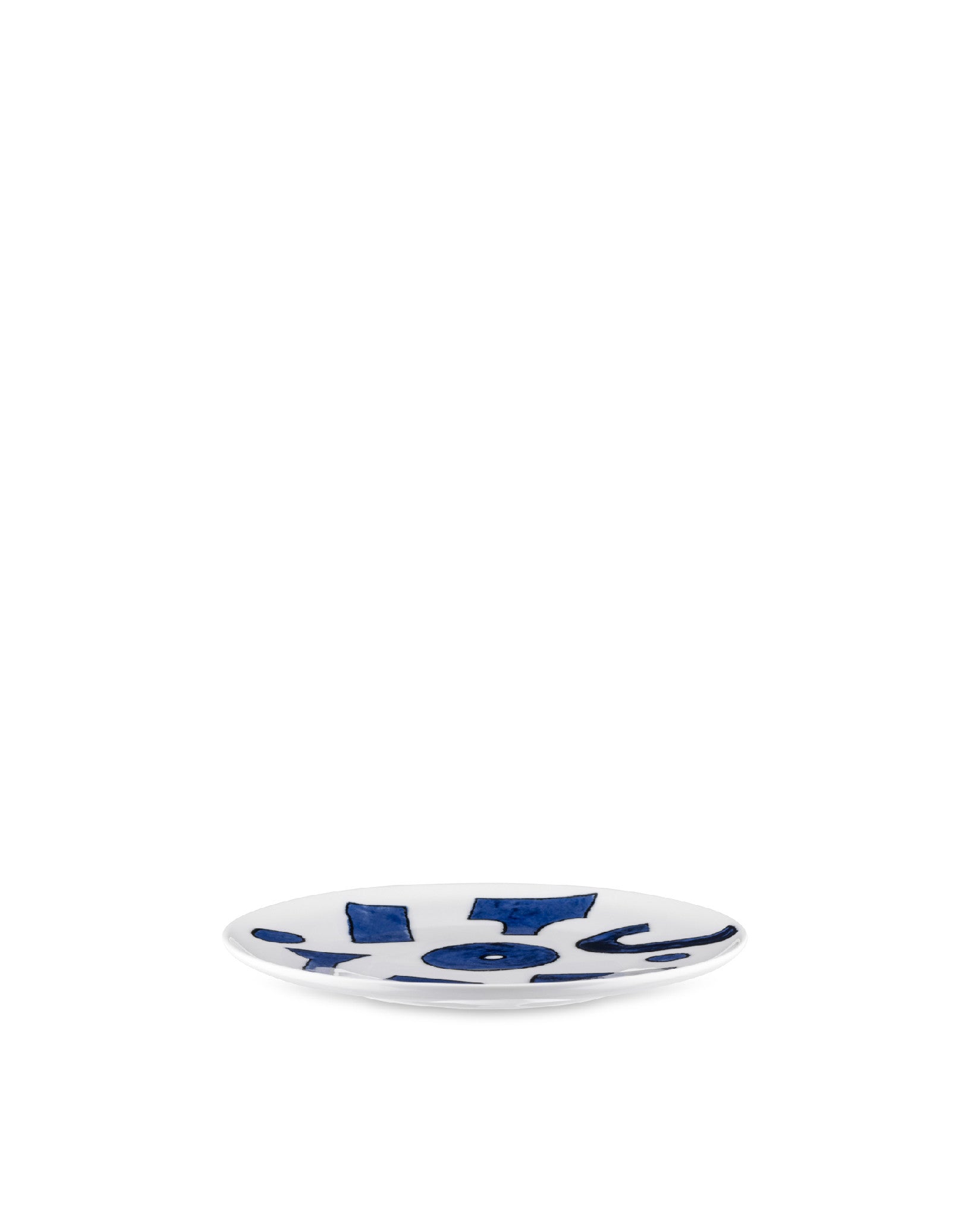 Small white ceramic dish by Alessi, featuring abstract blue patterns, viewed at a slight angle.