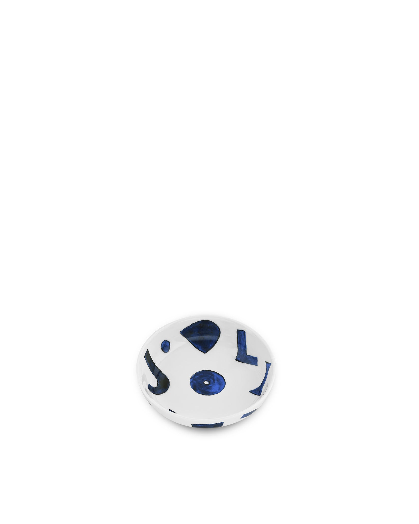 White ceramic cat bowl by Alessi, decorated with blue abstract shapes, seen from an overhead angle.