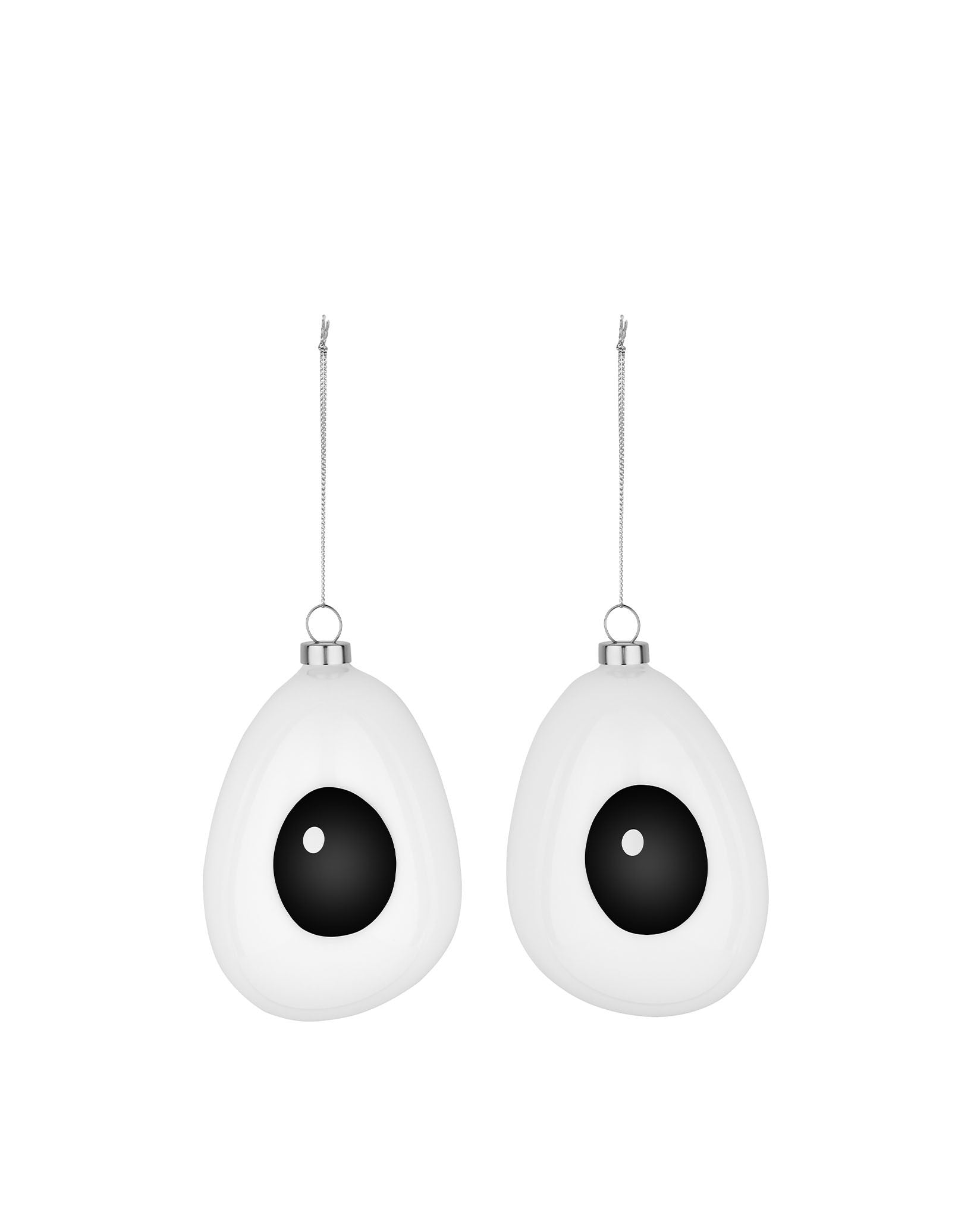 Two white, googly-eye shaped hanging decorations by Alessi, with black pupils and silver chains.