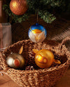 Blue, yellow, and white spherical Angioletto Christmas tree ornament by Alessi, featuring an angel design and hanging from a tree.