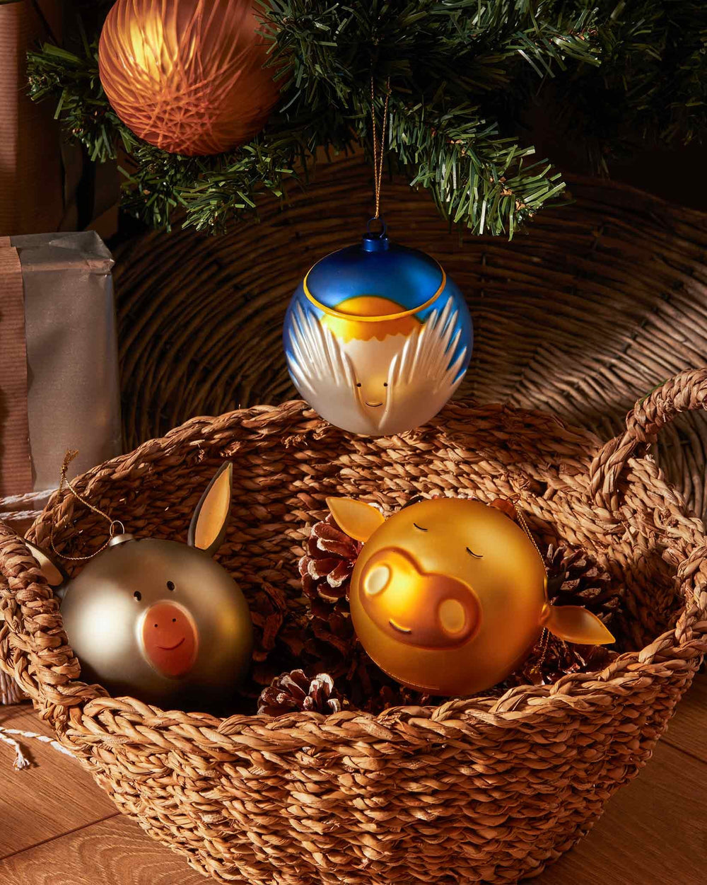 Blue, yellow, and white spherical Angioletto Christmas tree ornament by Alessi, featuring an angel design and hanging from a tree.