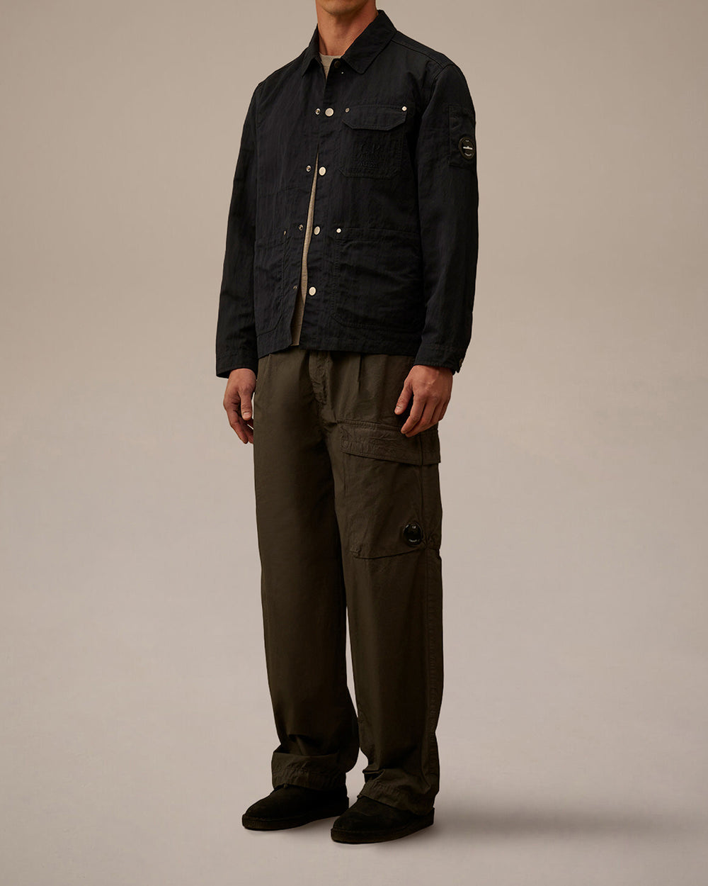 Dark navy jacket by Alessi with a subtle texture, light buttons, and a C.P. Company lens detail on the sleeve.