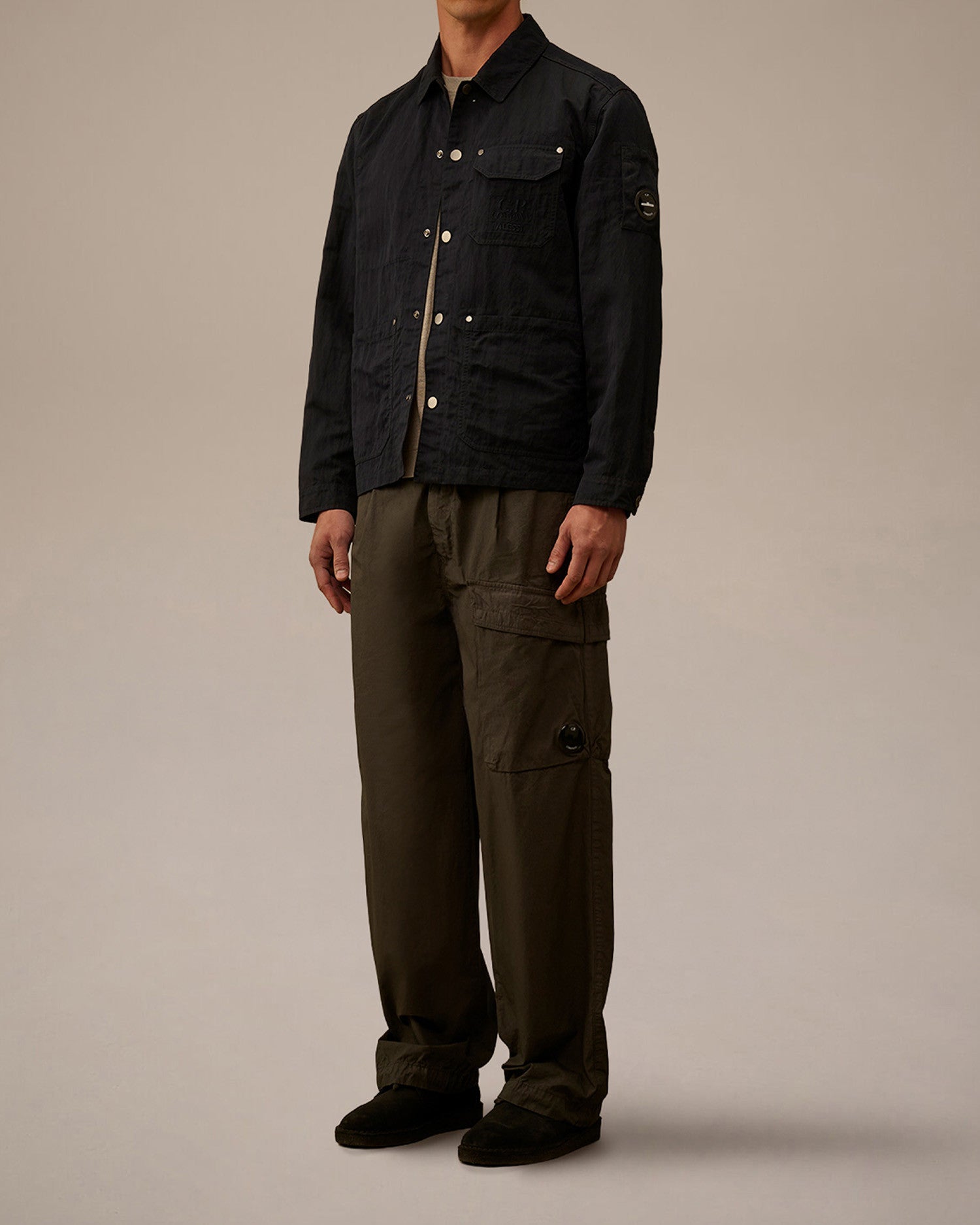 Dark navy jacket by Alessi with a subtle texture, light buttons, and a C.P. Company lens detail on the sleeve.