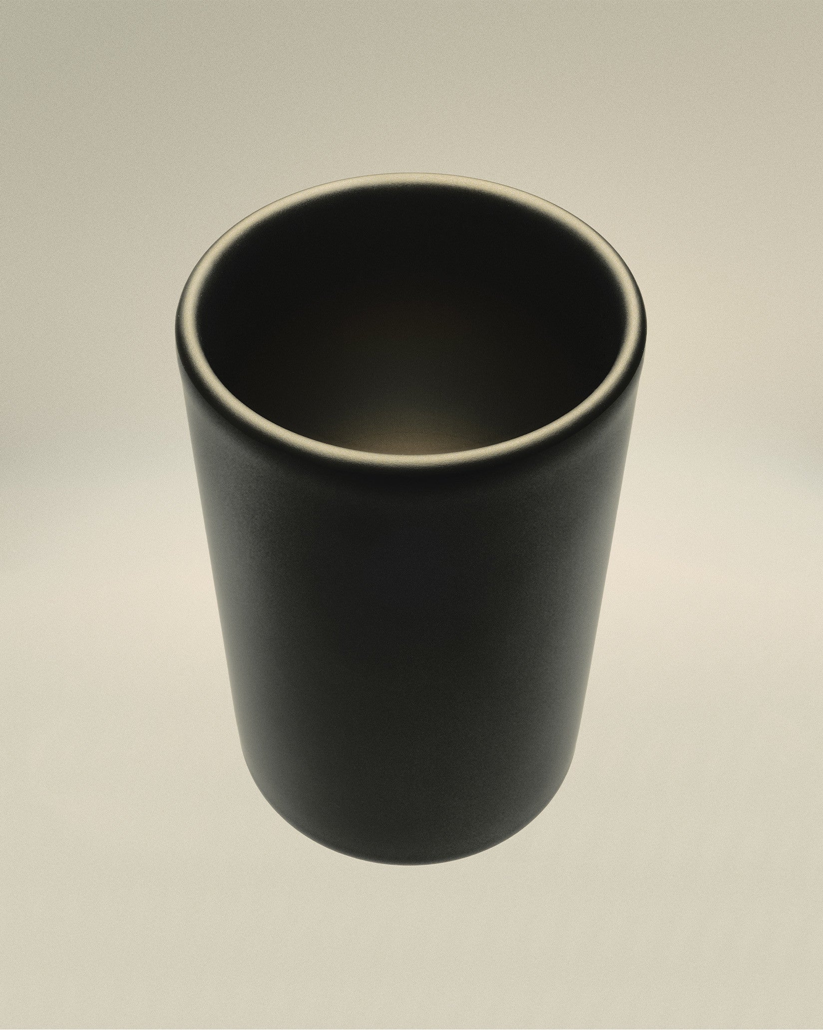 Dark grey matte cylindrical cup by Alessi, featuring a subtle rim highlight, viewed from above.