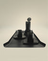 Matte black cups by Alessi, featured with a minimalist black coffee maker and stirrers on a coordinating dark tray.