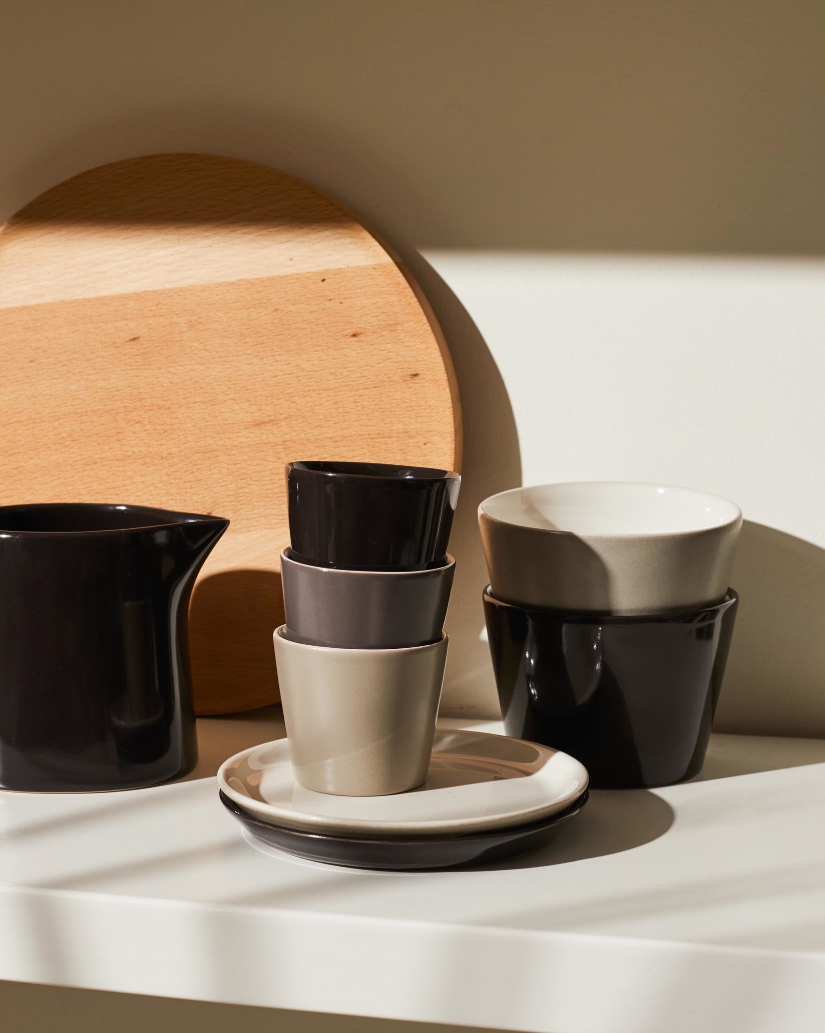 Tonale ceramic cups by Alessi, a stack of dark brown, grey, and beige, with matching pitcher and bowls.
