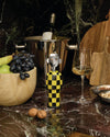 Yellow and black checkerboard corkscrew by Alessi, featuring a polished metal face.