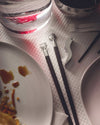 Designer chopsticks by Alessi with smiling character heads and dark wood handles, part of a sushi set.