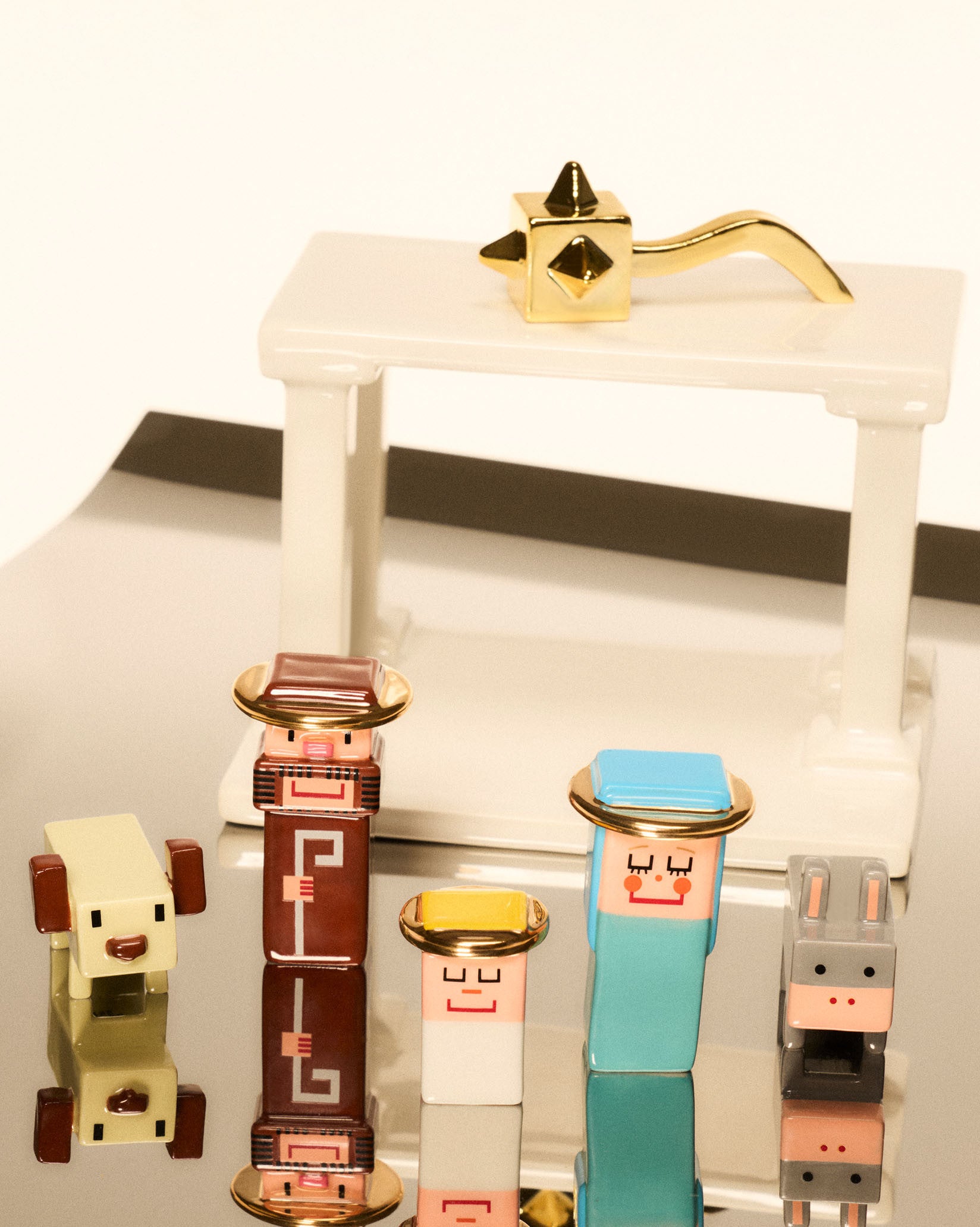 Miracolata ornamental figurines by Alessi, a colorful set of stylized blocky humans and animals on a reflective surface.