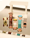 Colorful, stylized nativity set by Alessi, with blocky figures, gold accents, and white stable on reflective surface.