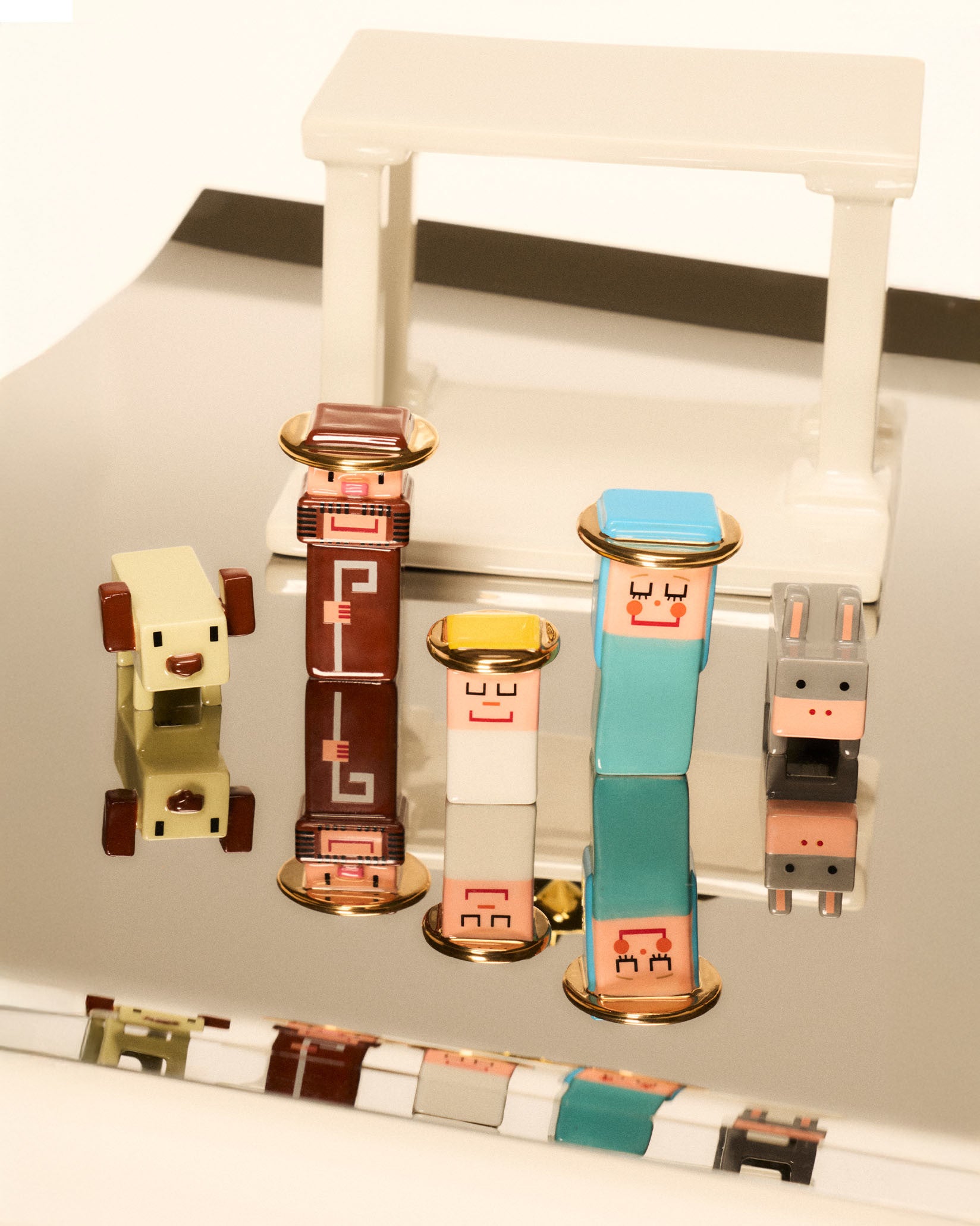 Colorful, stylized nativity set by Alessi, with blocky figures, gold accents, and white stable on reflective surface.