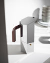 Geometric silver espresso coffee maker by Alessi with brown faceted handle and brass safety valve.