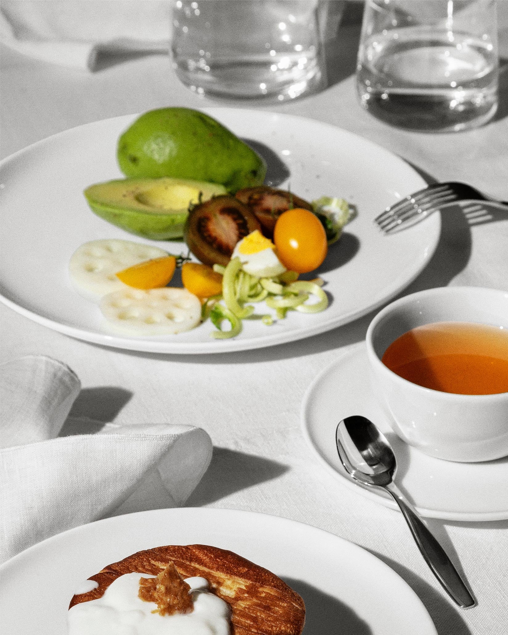 White ceramic dining plates by Alessi, simple and round, presented in a bright breakfast setting with fresh food.