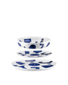 White porcelain table set by Alessi, featuring abstract blue shapes, stacked on a white background.