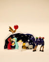 Colorful, glossy nativity set by Alessi, featuring stylized figures, a star-patterned tent, and a red smiling star.