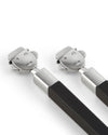 Pair of brushed metal and dark wood sushi sticks by Alessi, with smiling figure toppers, angled on a white surface.