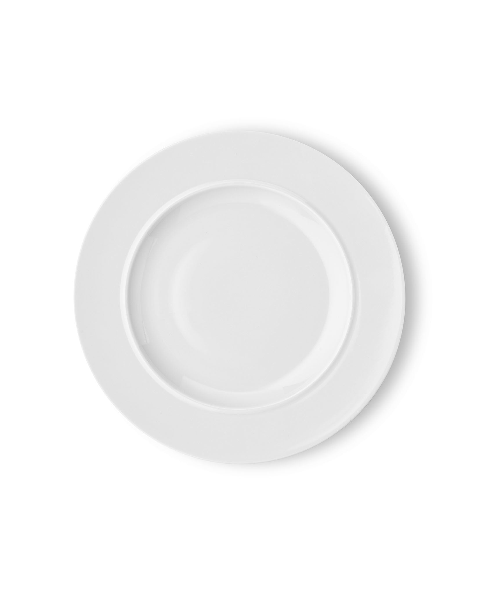 White round dining plate by Alessi, with a wide rim and a soft shadow, viewed from above.