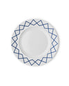 White ceramic dining plate by Alessi with a blue geometric zigzag pattern on the rim, from a top-down view.