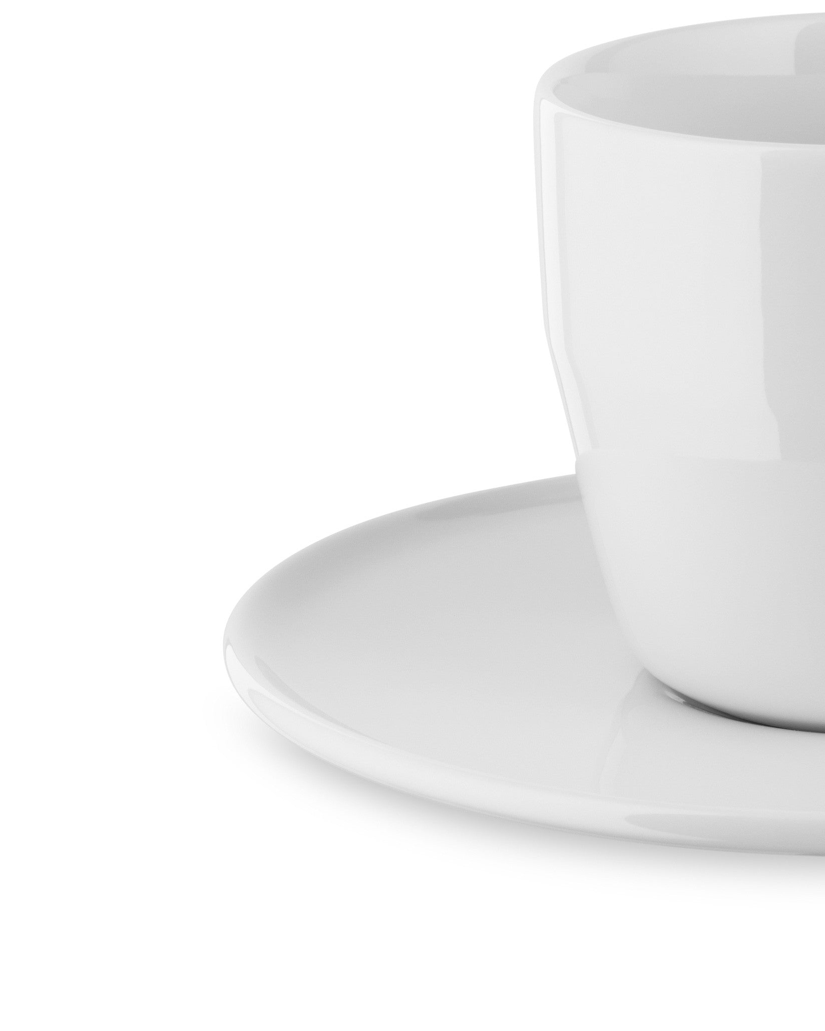 White ceramic cup and saucer by Alessi, featuring a glossy finish in a cropped, close-up shot.