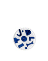 A white Yunoki ware plate by Alessi, decorated with abstract blue shapes and letters.
