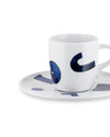 White ceramic espresso cup and saucer by Alessi, decorated with abstract blue brushstroke patterns.