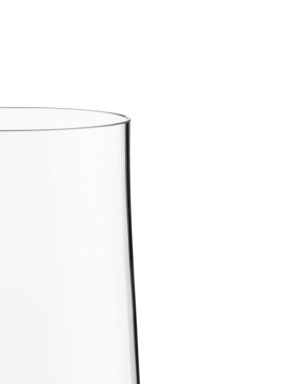 Clear glass pitcher by Alessi, close-up view of its curved rim and side.