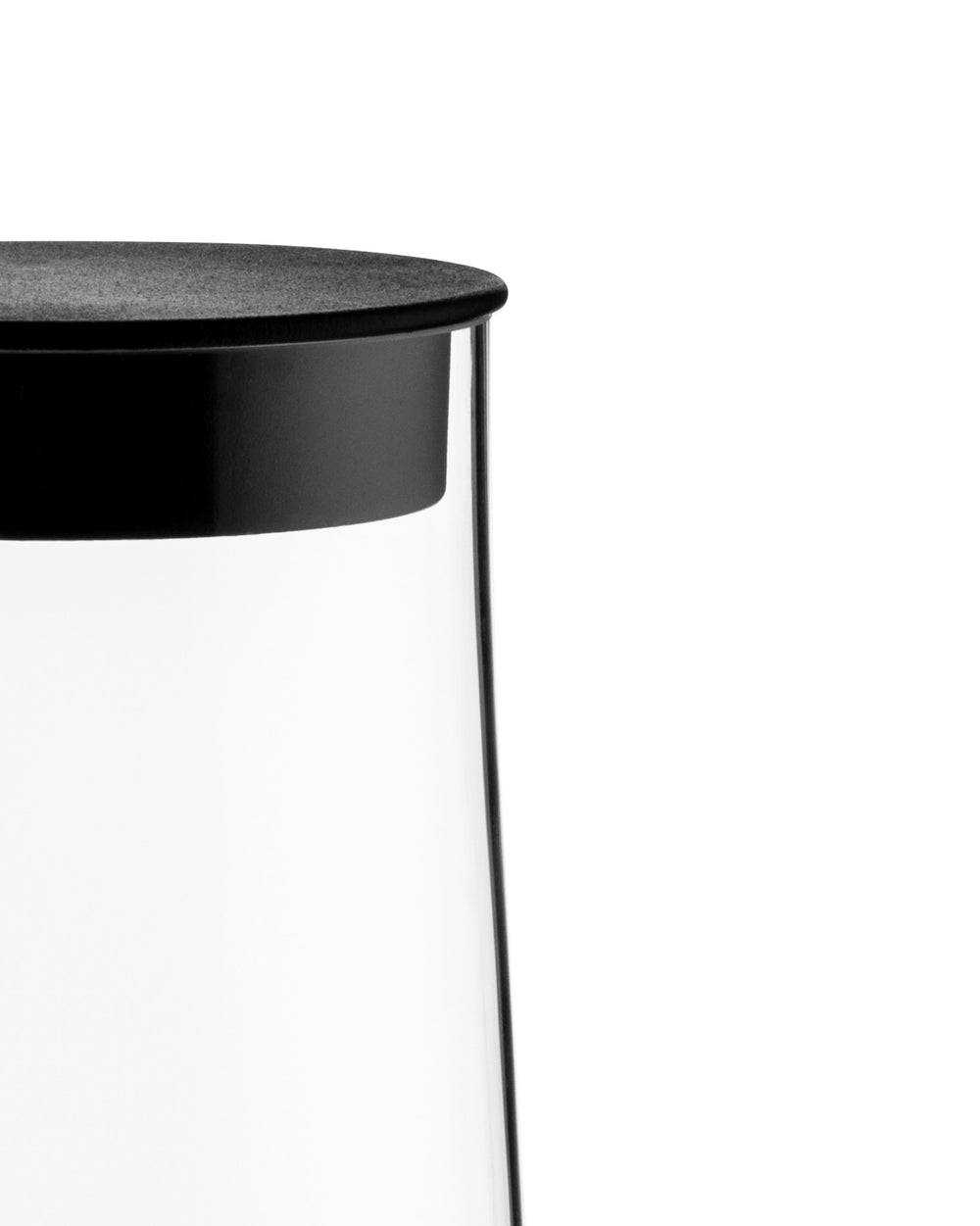 Clear glass pitcher with textured black lid by Alessi, cropped close-up.