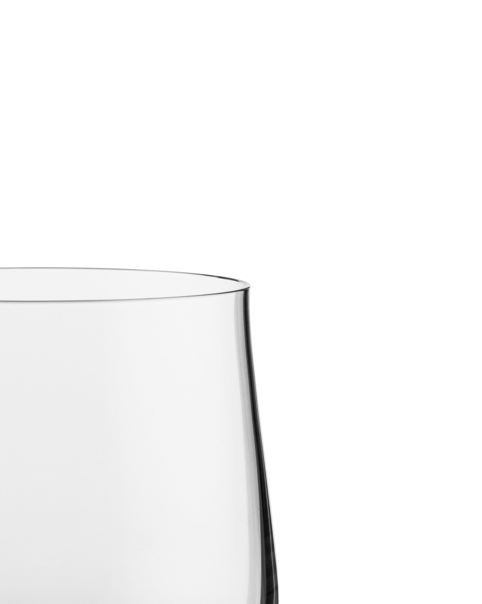 Clear water glass by Alessi, cropped close-up showing the curved rim and transparent body.