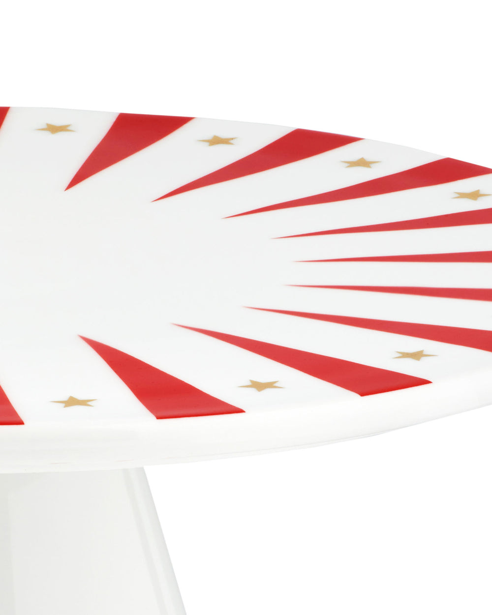 White stand by Alessi, with a festive red striped and gold star pattern, angled close-up.