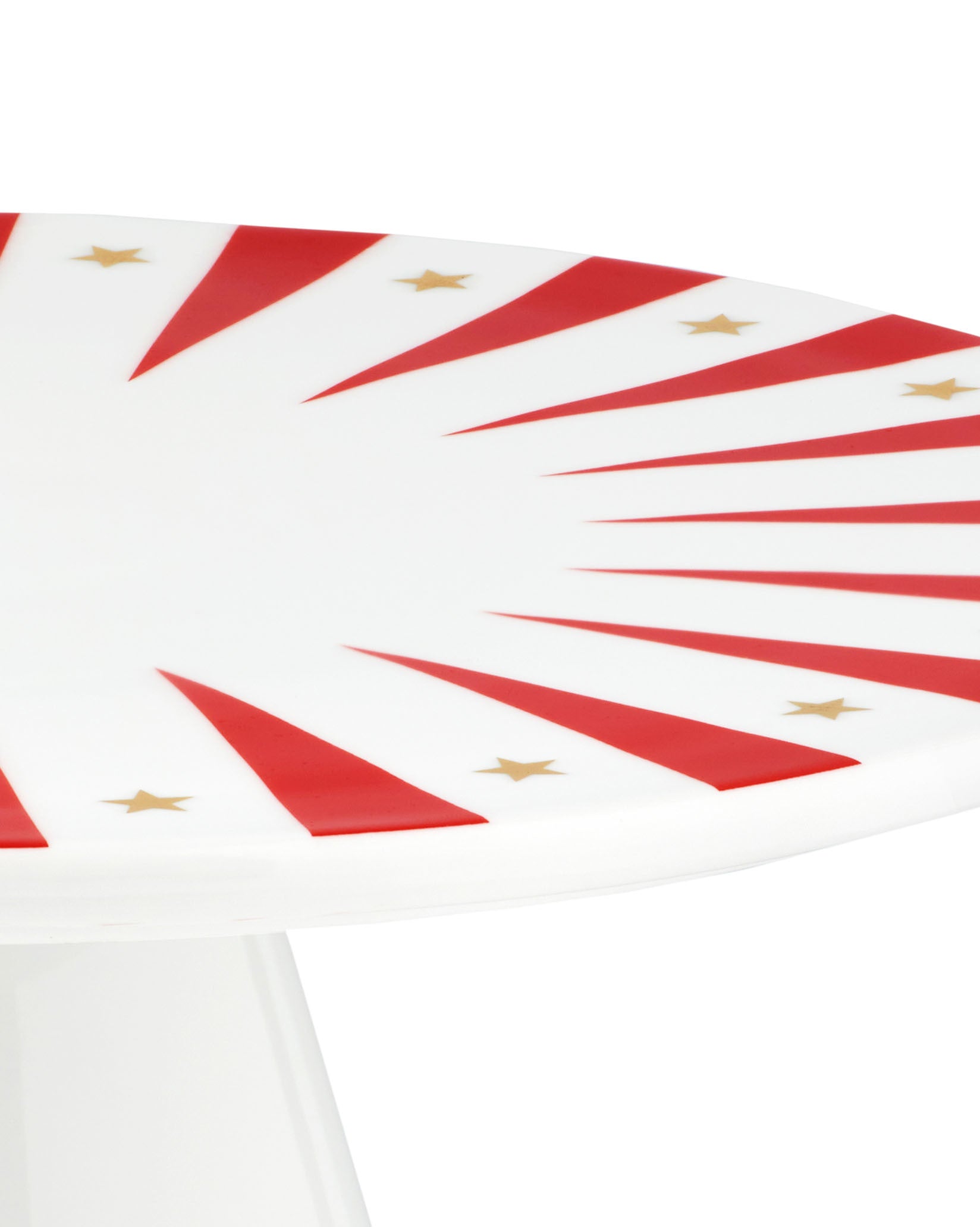 White stand by Alessi, with a festive red striped and gold star pattern, angled close-up.