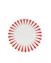 White round decorative plate by Alessi with radial red stripes and golden stars in a festive design.