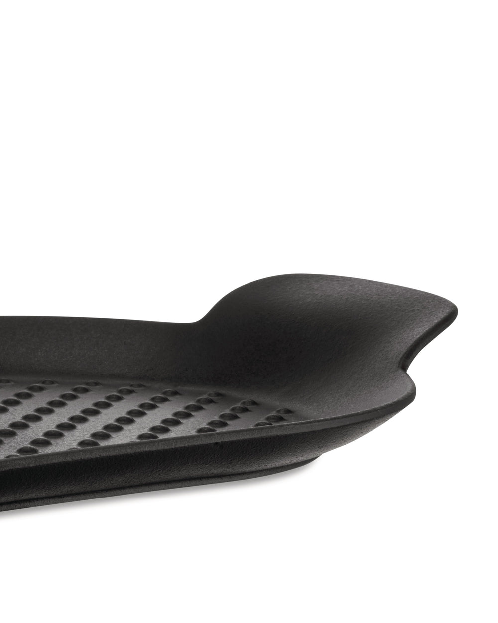 Black grill pan by Alessi, a close-up side view showing its dimpled grid pattern and curved handle.