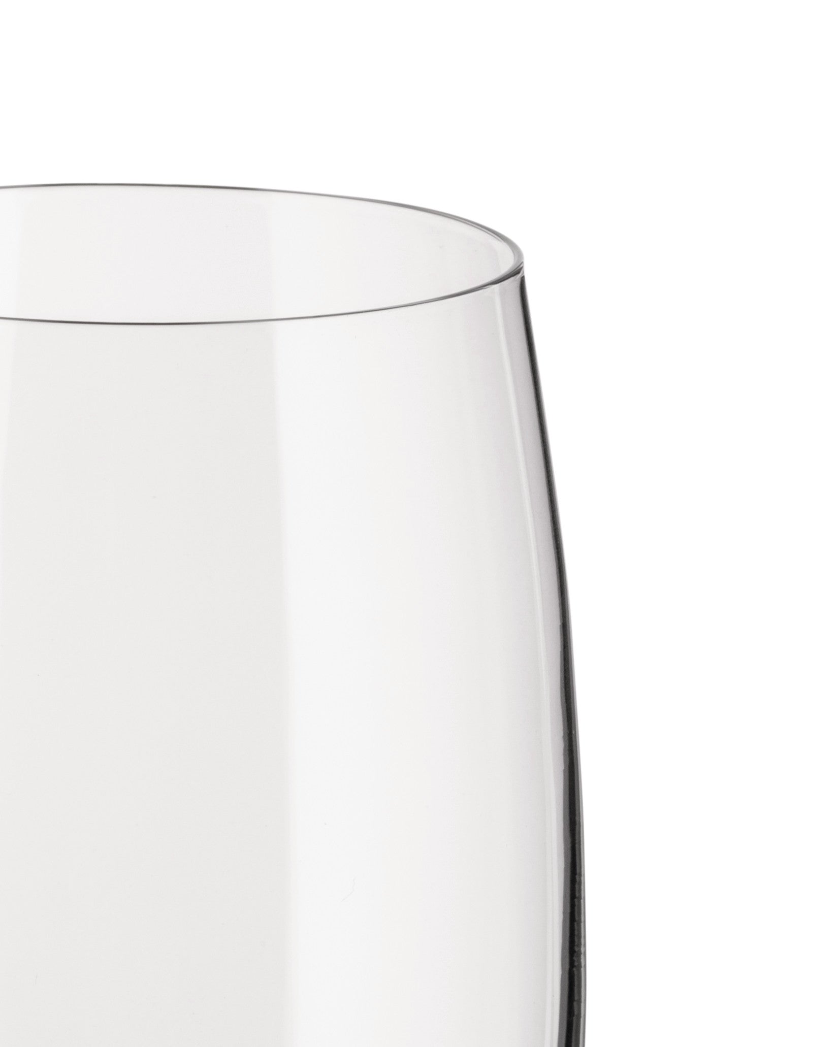 Clear glass champagne flute by Alessi with a curved rim, showing its transparent body cropped against white.