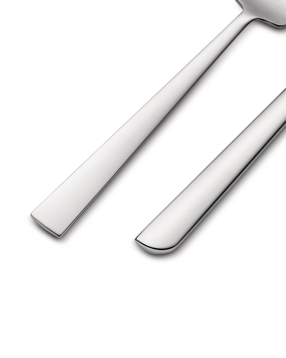 Polished silver flatware by Alessi, with sleek handles angled on a clean white background.