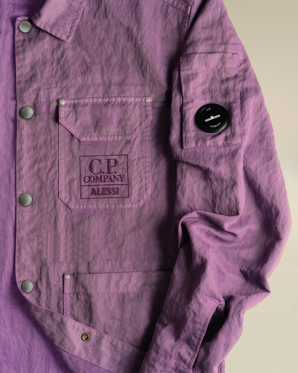 Purple crinkled jacket by Alessi, with C.P. Company chest embroidery and arm lens.