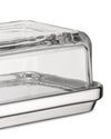 Glass and polished silver-tone butter dish by Alessi with a clear rectangular glass cover, viewed from the side.