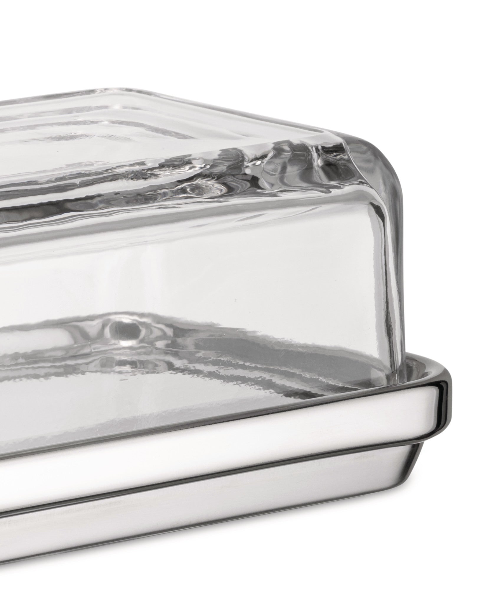 Glass and polished silver-tone butter dish by Alessi with a clear rectangular glass cover, viewed from the side.