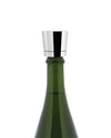 Silver metal stopper by Alessi on a dark green bottle, featuring reflective surfaces.