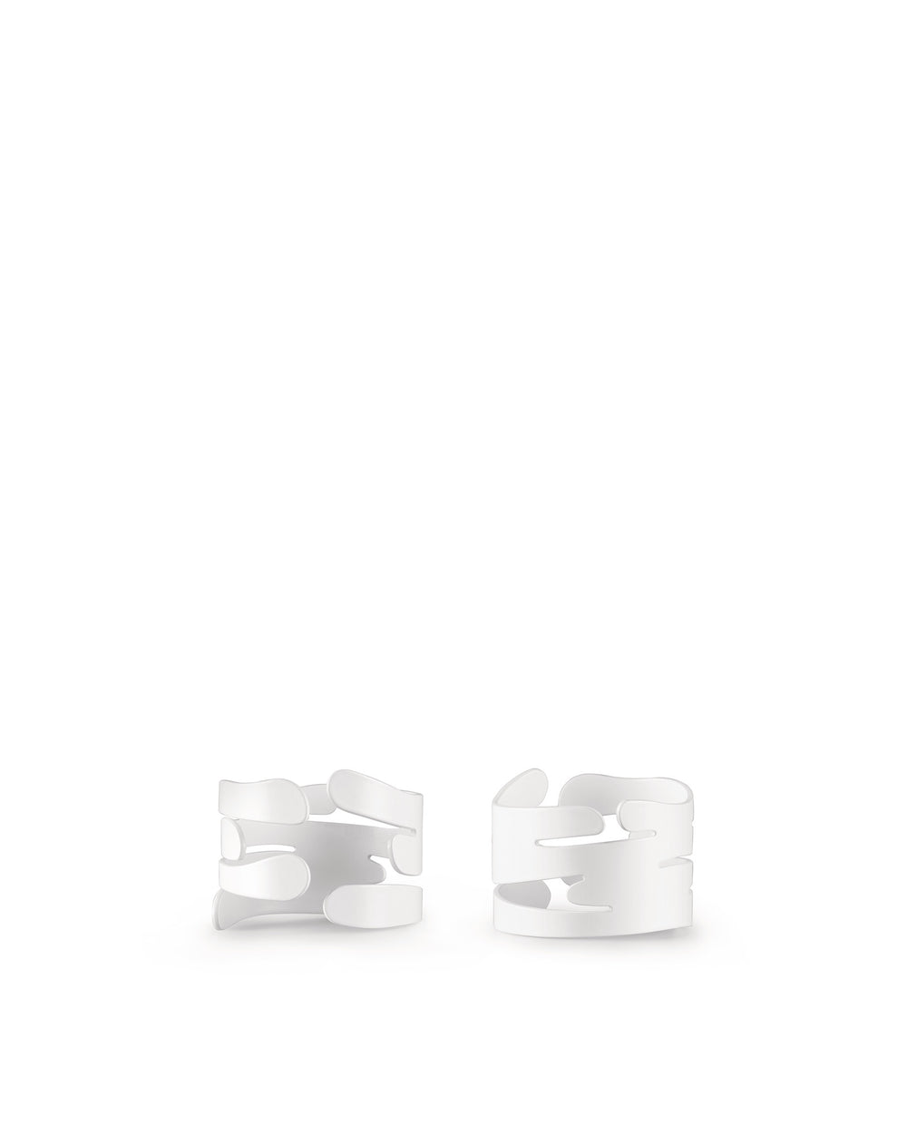 Two white abstract napkin holders by Alessi, with flowing, tree bark-like cut-out designs, shown front view.