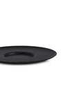 Black matte cup by Alessi, with a wide, shallow profile and subtle central indentation, shown low angle.