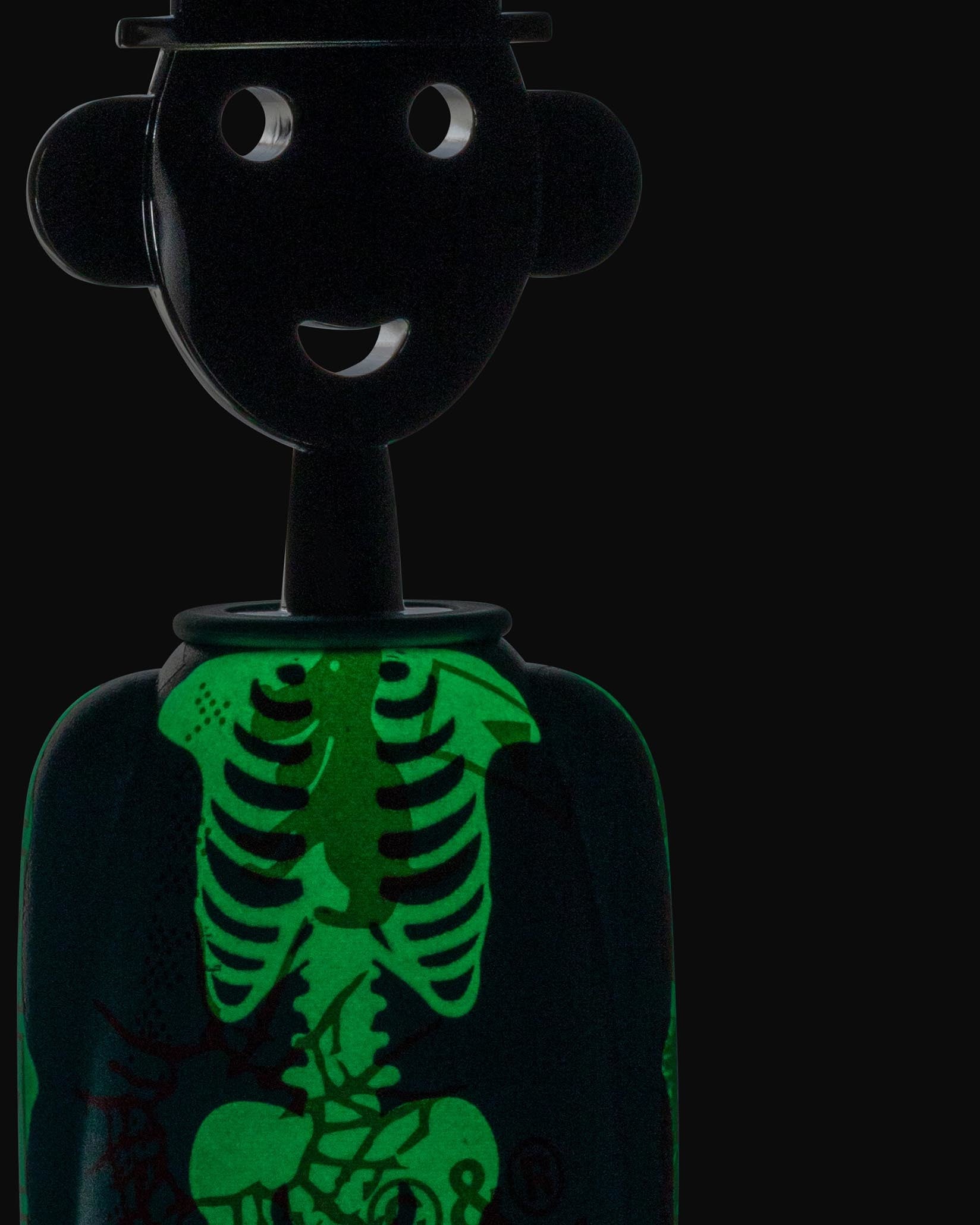 Black anthropomorphic corkscrew by Alessi with a smiling face, hat, and glowing green skeleton design.