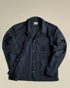 Dark blue crinkled jacket by Alessi featuring C.P. Company branding on chest and sleeve, laid flat.